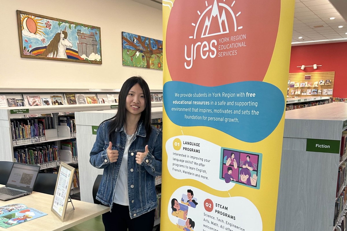 Volunteer standing next to YRES banner at info session